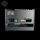 The rear view of a black Marshall Deliever 7 guitar amplifier, showing the input jacks, control labels, vent grilles, and internal components against a solid black background.