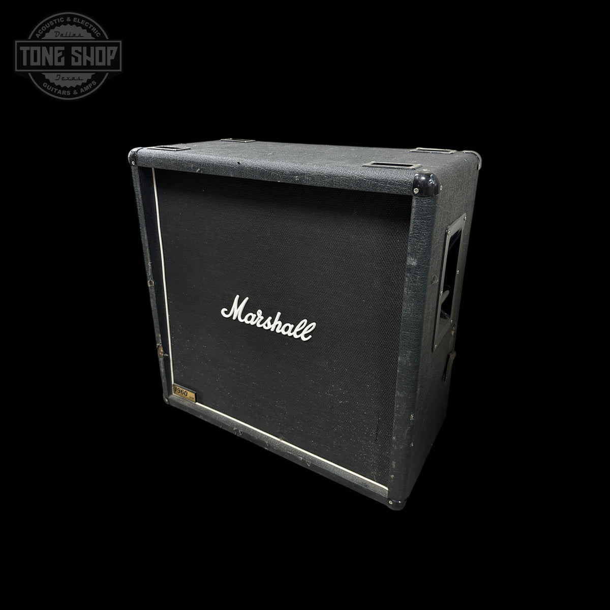A vintage Marshall speaker cabinet with a black front grille and white script logo, shown at an angle against a solid black background.