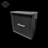 A vintage Marshall speaker cabinet with a black front grille and white script logo, shown at an angle against a solid black background.