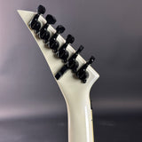 Close-up of a guitar's headstock with tuning pegs against a gray background