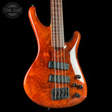 Electric bass guitar with a glossy finish on a black background, featuring the Tone Shop logo.