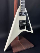 White electric guitar with a brown pickguard on a black background