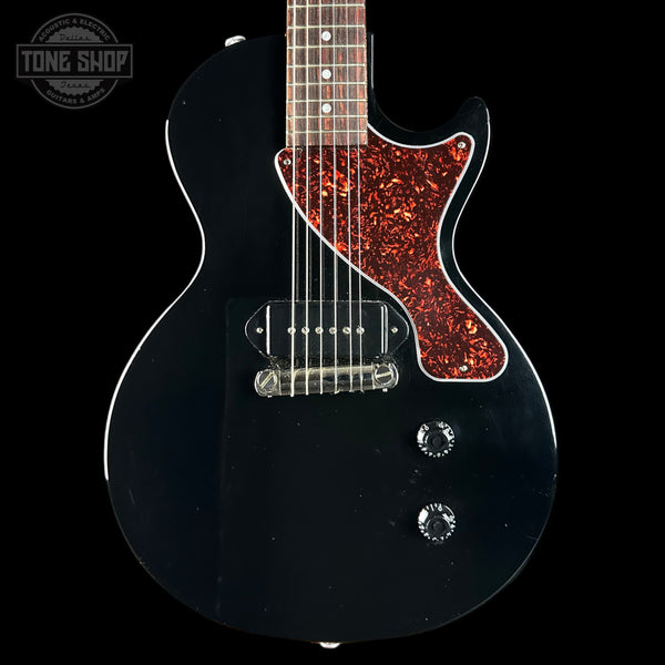 Black electric guitar with red flamed maple top on a black background, featuring 'Tone Shop' logo.