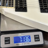 Electric guitar on a digital scale displaying weight