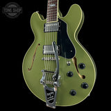 Green electric guitar with a black pickguard on a black background, featuring the Tone Shop logo.