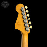 Close-up of the headstock of an electric guitar, showing the maple wood finish, six silver tuning pegs, and cream-colored tuning keys against a solid black background.