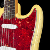 Close-up of a vintage-style electric guitar body with a bright red textured pickguard and a natural light wood body, shown against a black background.
