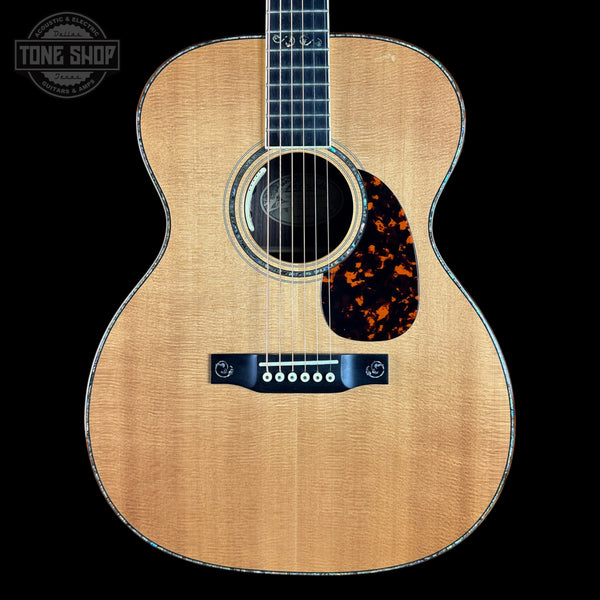 Acoustic guitar with tortoiseshell pickguard on a black background, featuring 'Tone Shop' logo.