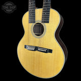 Acoustic guitar with a visible brand logo on a black background