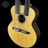 Acoustic guitar with a double neck design on a black background, featuring the Tone Shop logo.