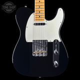 A black electric guitar with a white pickguard and maple fretboard, shown from the front against a black background. A Tone Shop watermark is visible in the top-left corner.