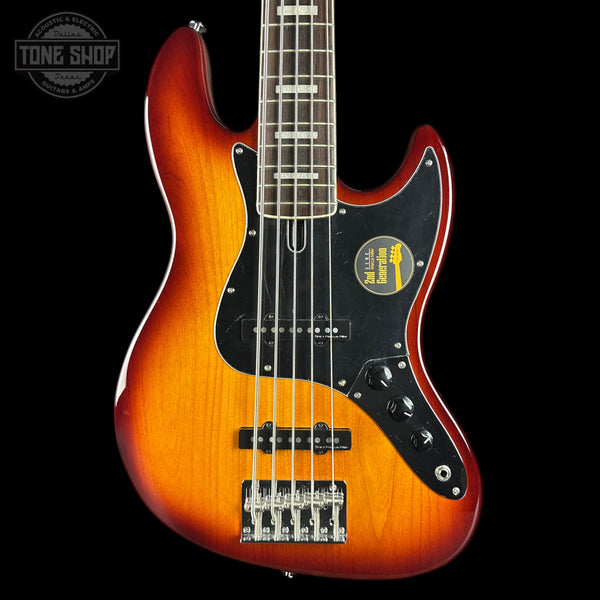 Electric bass guitar with a sunburst finish on a black background, featuring the Tone Shop logo.