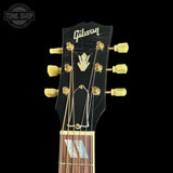 Gibson guitar headstock with brand logo on a black background