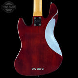 Red electric guitar with a white pickguard on a black background, featuring 'Tone Shop' branding.