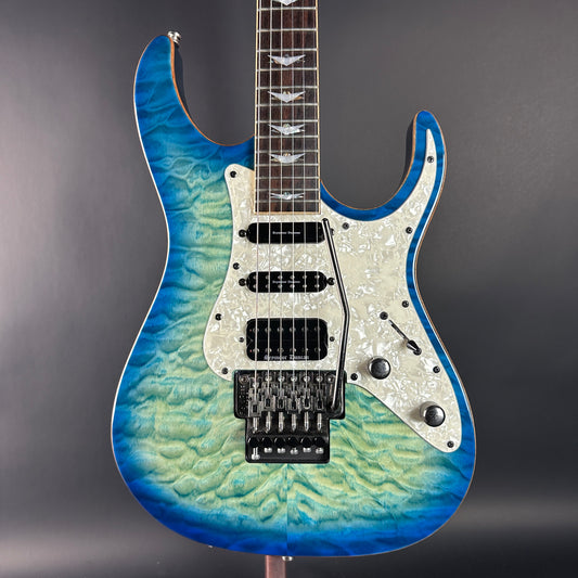 Blue and green electric guitar on a gray background