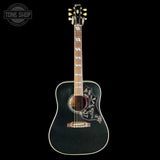 Acoustic guitar with decorative inlay on a black background, featuring the Tone Shop logo.