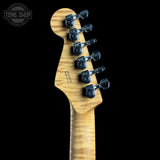 Close-up rear view of an electric guitar headstock with six black tuning pegs and a natural wood grain finish, shown against a black background with a Tone Shop watermark in the upper left.