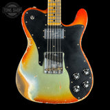 Electric guitar with a multicolored body on a black background, featuring the Tone Shop logo.