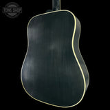 Back view of a black acoustic guitar with a white binding on a black background, featuring 'Tone Shop' logo.