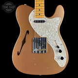 Electric guitar with a brown body and white pickguard on a black background, featuring 'Tone Shop' branding.