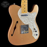 Electric guitar with a blonde finish and pearl inlay on a black background