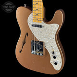Brown electric guitar with a pearl inlay on a black background, featuring 'Tone Shop' branding.