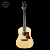 Acoustic guitar with a visible brand logo on a black background