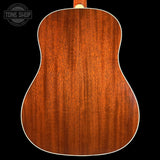 Close-up of a wooden acoustic guitar back with 'Tone Shop' logo.