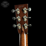 Close-up of a guitar headstock with tuning pegs on a black background, featuring the Tone Shop logo.