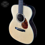 Acoustic guitar with a visible brand logo on a black background