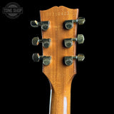 Guitar headstock with tuning pegs on a black background, featuring the Gibson logo.