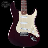 A classic electric guitar with a glossy deep burgundy body, cream pickguard, and chrome hardware, shown against a solid black background. A Tone Shop watermark is visible in the top-left corner.