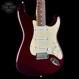 A classic electric guitar with a glossy dark red body, cream-colored pickguard, and chrome hardware, shown against a solid black background with a Tone Shop watermark in the top-left corner.