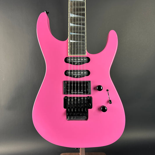 Pink electric guitar on a gray background