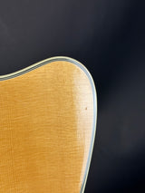 Close-up of a wooden guitar headstock with a dark background