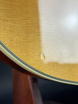 Close-up of a guitar's soundhole with a white pickguard.