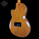 Back view of a wooden electric guitar with 'Tone Shop' logo.