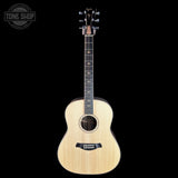A natural wood acoustic guitar with a dark fretboard and headstock, shown vertically against a solid black background. A circular 'TONE SHOP' watermark is visible in the top-left corner.