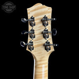 Close-up of a guitar headstock with tuning pegs on a black background, featuring the Tone Shop logo.