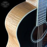 Close-up of an acoustic guitar with a visible brand logo in the corner.