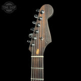 Close-up of a Fender electric guitar headstock and upper neck, showing six tuning pegs, a dark wood finish, and a small maple inlay, photographed against a black background with a Tone Shop watermark in the top left.