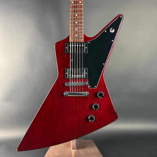 Red electric guitar with a black pickguard on a gray background