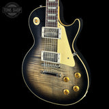 A close-up of an electric guitar body against a black background, featuring a natural flame maple wood grain finish with a dark sunburst edge, cream pickguard, and gold hardware. A 'TONE SHOP' watermark is visible in the top-left corner.
