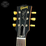 Gibson Les Paul guitar headstock with yellow tuning pegs on a black background