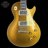 Gold electric guitar with a 'Tone Shop' logo in the corner