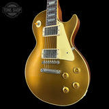 Gold electric guitar on a black background with 'Tone Shop' logo.