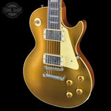 Gold electric guitar with a 'Tone Shop' logo in the corner