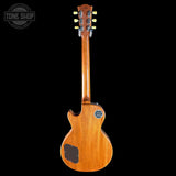 Wooden electric guitar with a headstock on a black background, featuring the Tone Shop logo.