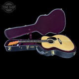 Acoustic guitar in an open case with 'Tone Shop' branding.