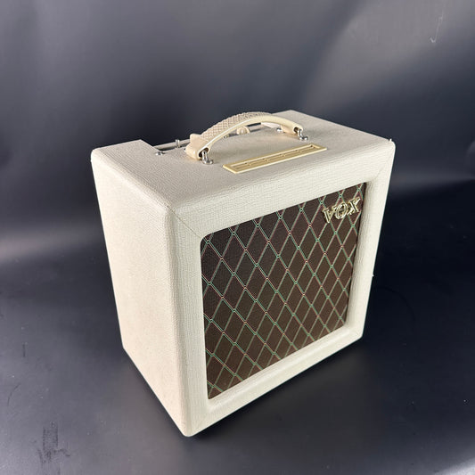 White guitar amplifier with a grid pattern on a dark background